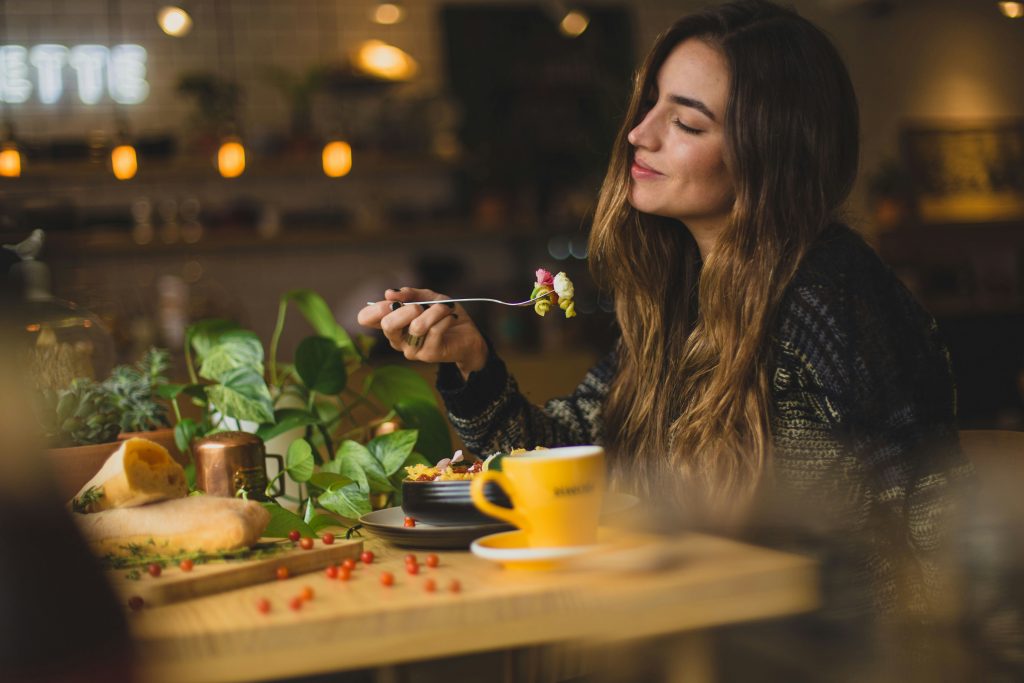 スタイルの良い女性が食事している画像